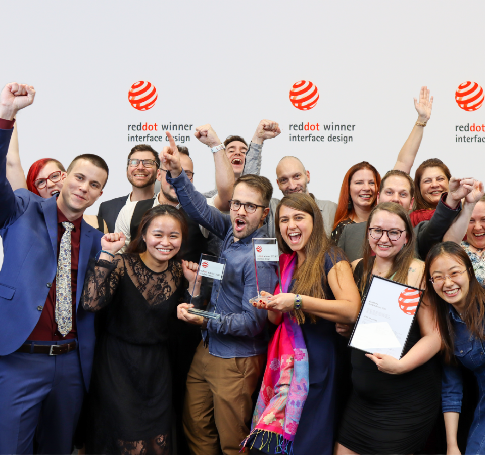Das Team von Custom Medical jubelt und feiert den Gewinn des Red Dot Design Awards 2022.