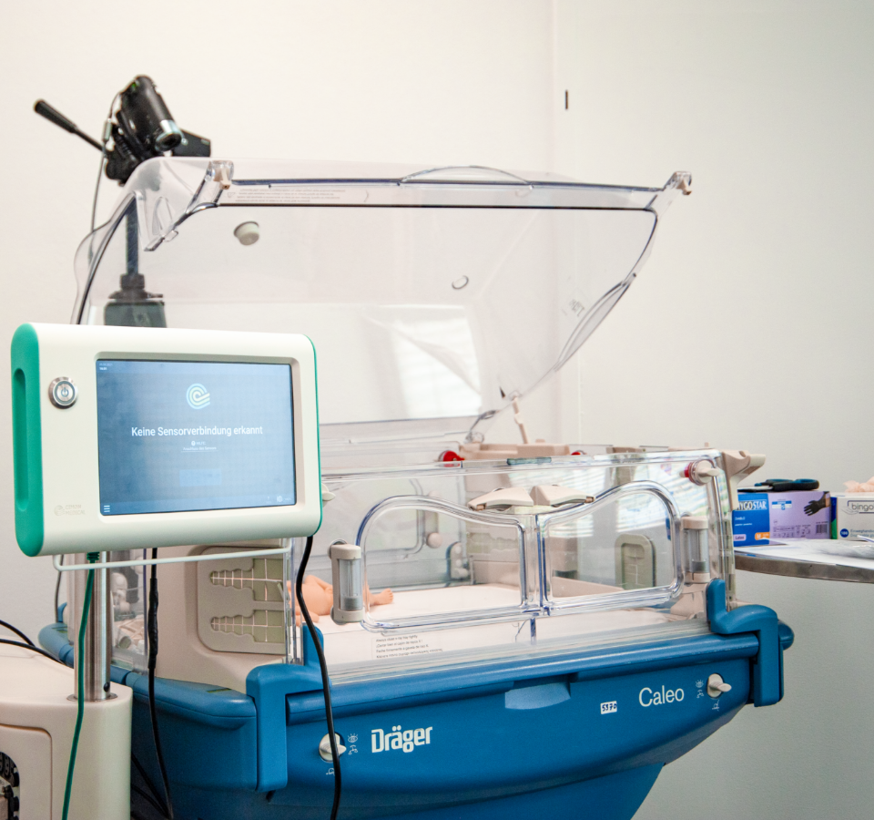 An incubator. The interface of the NeoDoppler is visible in front of it on the left.