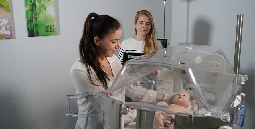 Zwei Mitarbeiterinnen von Custom Medical stehen an einem Inkubator, mit dem eine summative Evaluation durchgeführt wird.