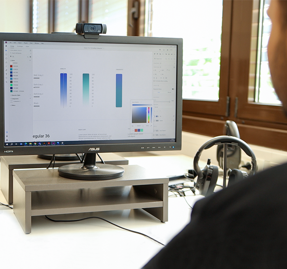 An employee sits in front of a screen on which a style guide can be seen.